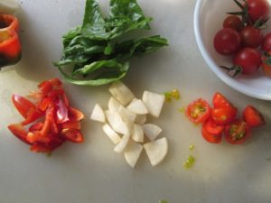 Half the tomatoes and chop the veggies